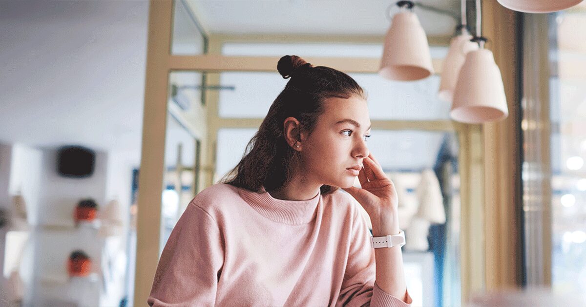 Thoughtful high school student considering how an unexpected pregnancy could affect her education and future plans.
